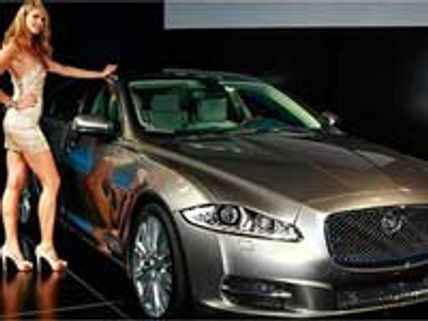 Macpherson poses next to new Jaguar XJ during launch