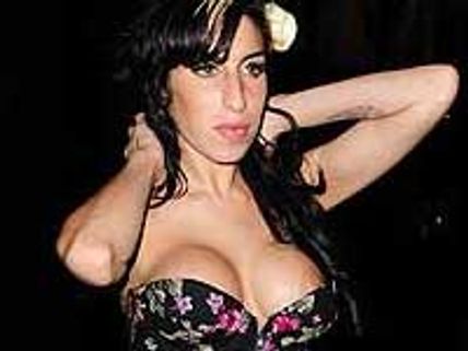Amy Winehouse's boobs busts out of her top