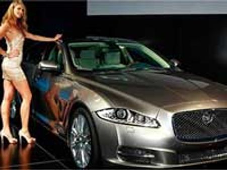 Macpherson poses next to new Jaguar XJ during launch