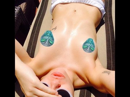 Miley Cyrus Posts A Topless Sunbathing Pic, Covers Assets With Alien Heads