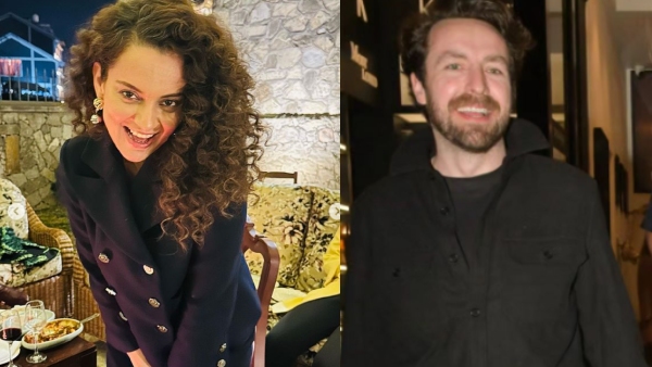 Actress Kangana Ranaut smiles as she holds hands with a foreigner