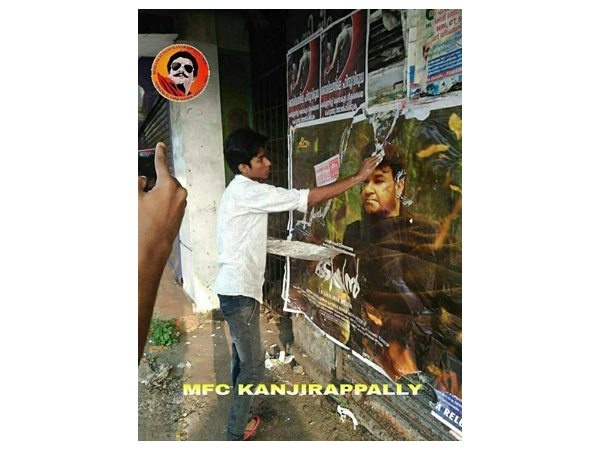 പോസ്റ്റര്‍ തിരിച്ചൊട്ടിക്കുന്നു