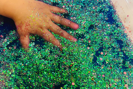 Malti playing with glitters.
