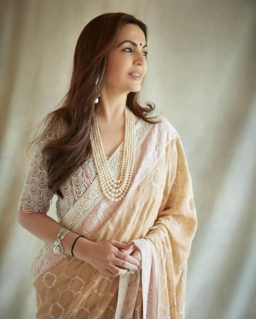 Nita Ambani looks stunning in a cream saree elegantly paired with a blouse adorned with pearls.
