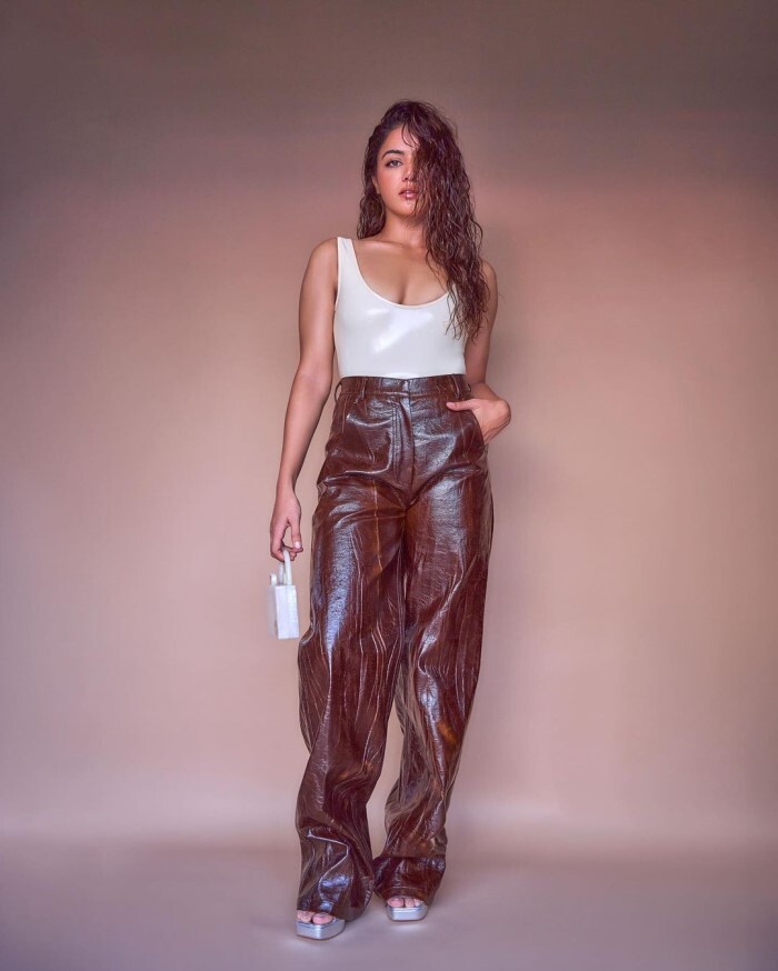 Paired with the tank top, she wore luxurious brown leather pants that shimmered under the light