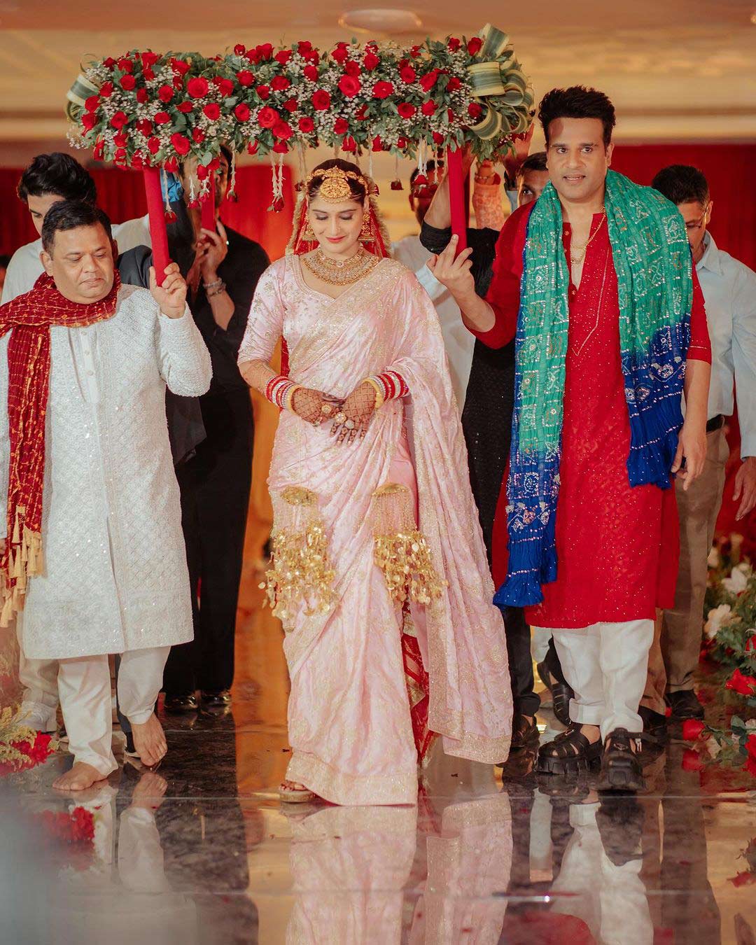 During the pheras (wedding rituals), Arti changed into a baby pink-toned saree.