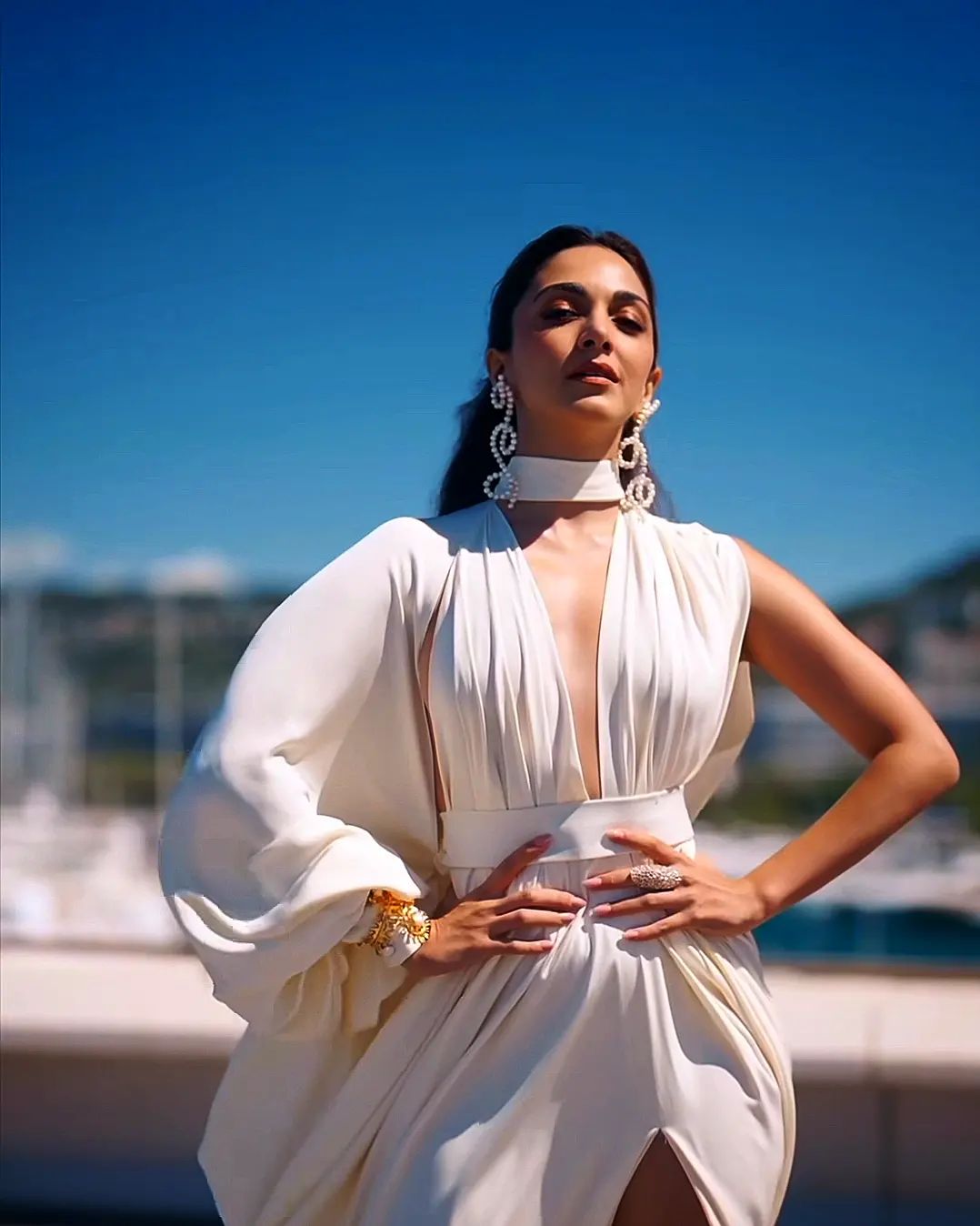 Kiara Exudes Sophistication in White Satin Gown with Daring Slit and Plunging Neckline