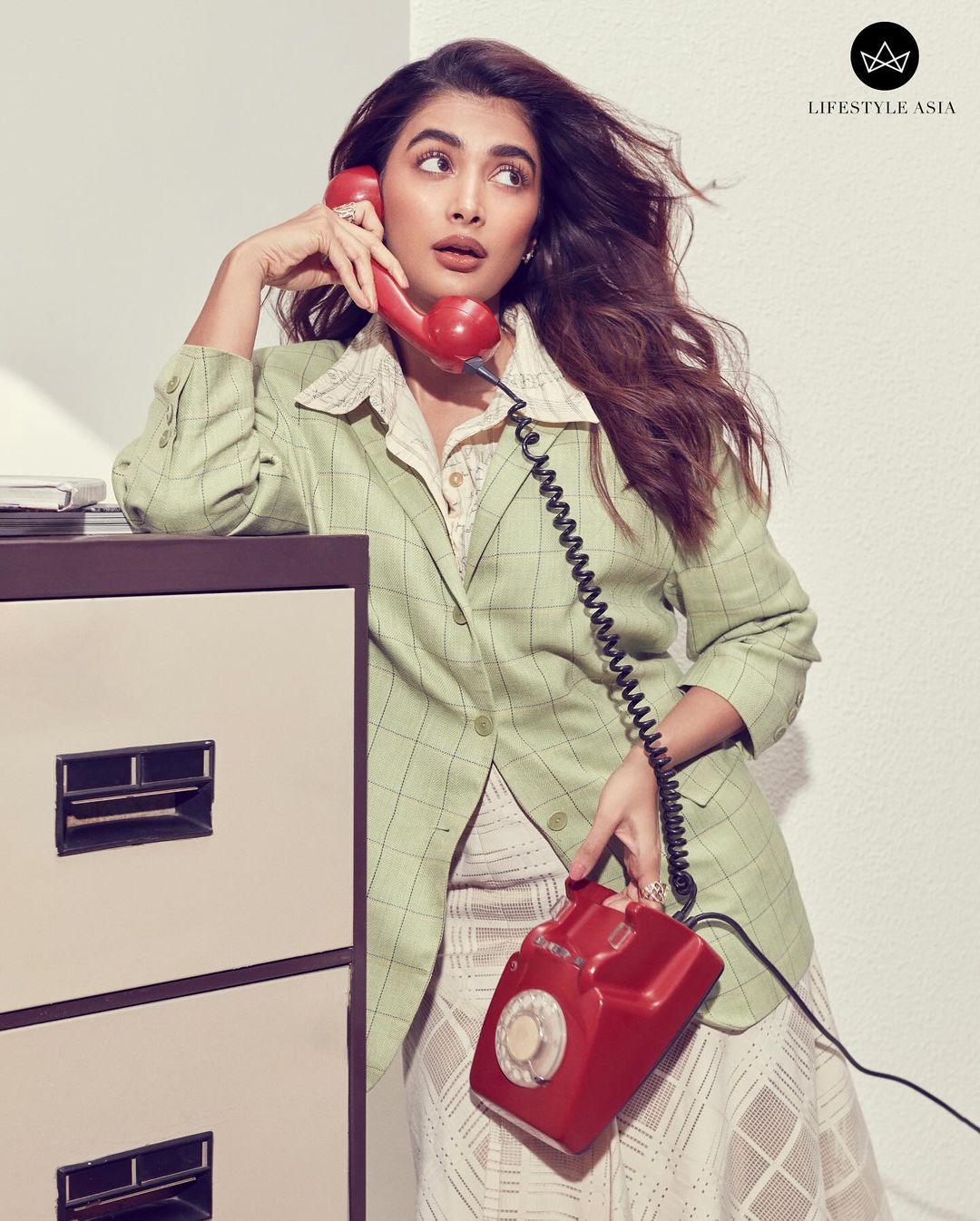 Pooja can be seen leaning against a rack, posing with a telephone. She wore a blazer and shirt from The Tangerine, paired with a skirt from Kanika Goyal Label.