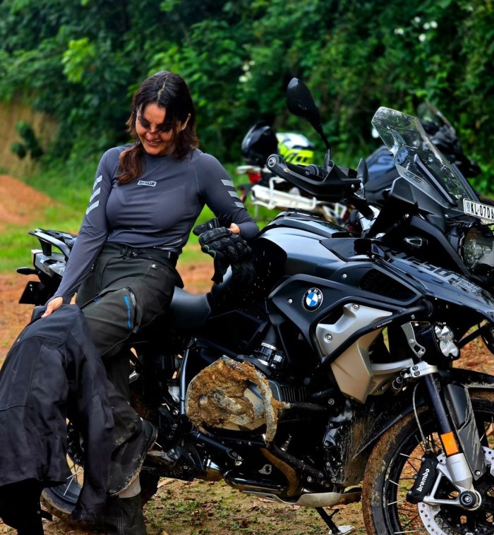 The images show Manju sitting on a BMW GS 1250, smiling at the camera, and laughing candidly while looking down