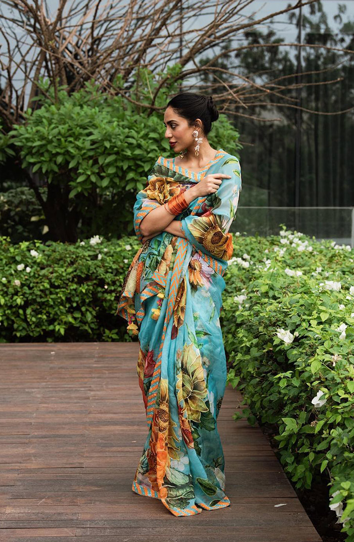 In a vibrant saree adorned with roses throughout, Sobhita Dhulipala embraces her lively personality with flair