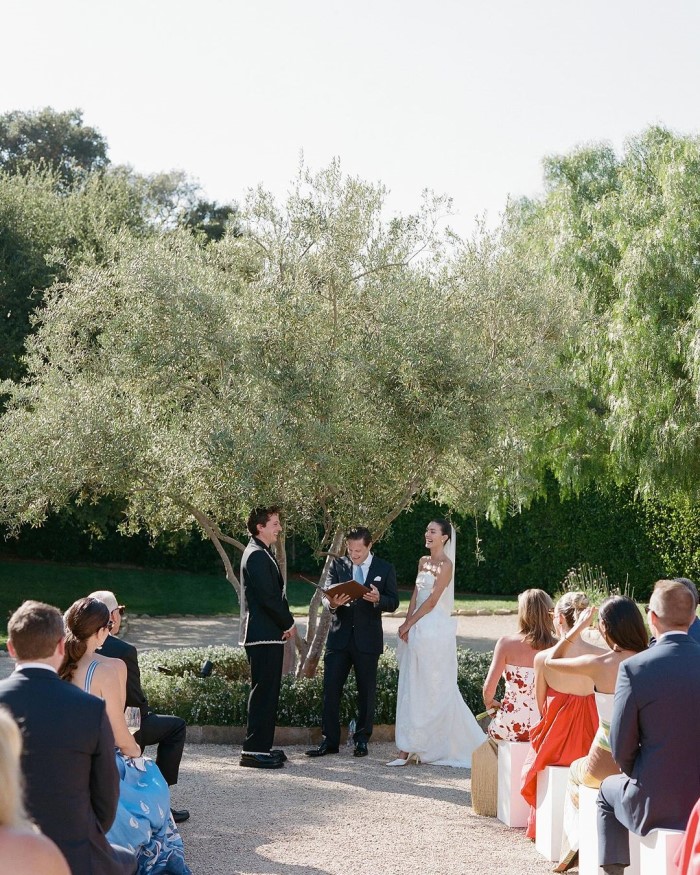 The ceremony was intimate, held in the driveway of the family home, in front of an olive tree.