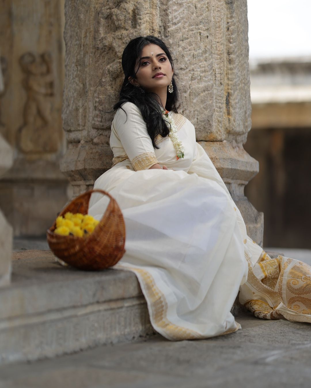 Megha Shetty is seen wearing a beautiful cream-colored saree with a gold border.