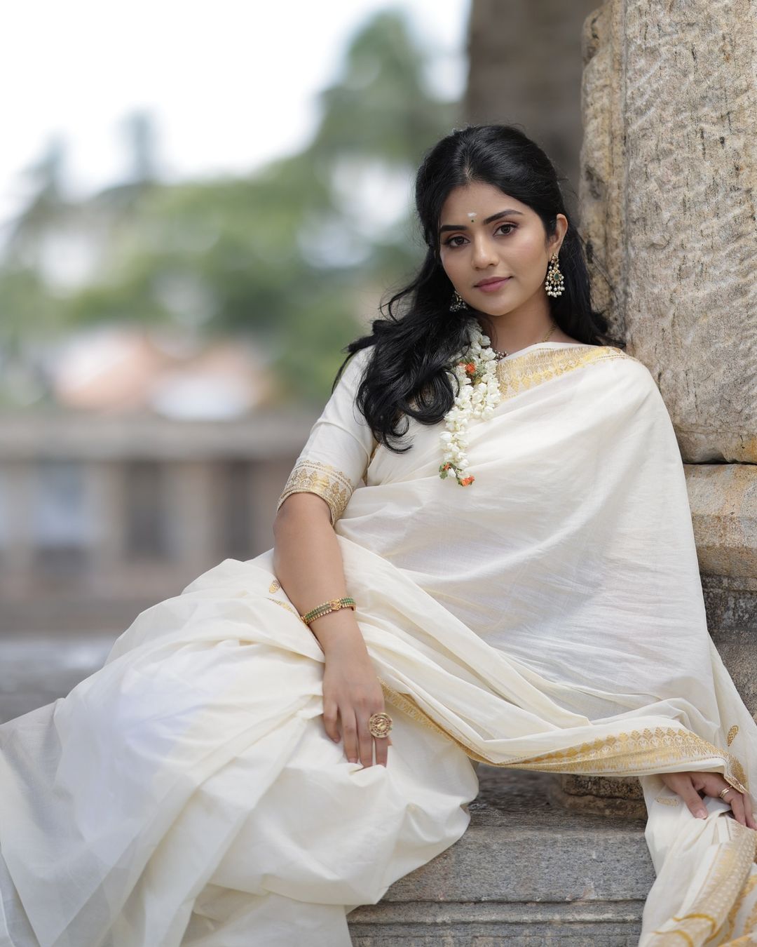 Megha Shetty is seen wearing a beautiful cream-colored saree with a gold border.