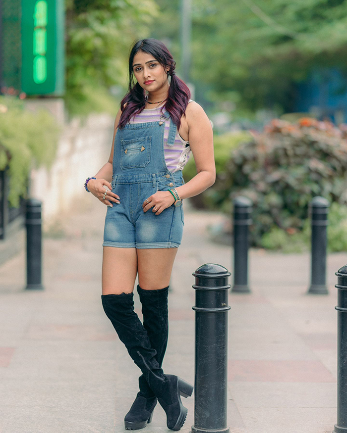 She completes her look with a pair of black knee-high boots, adding an edgy contrast to the casual outfit.