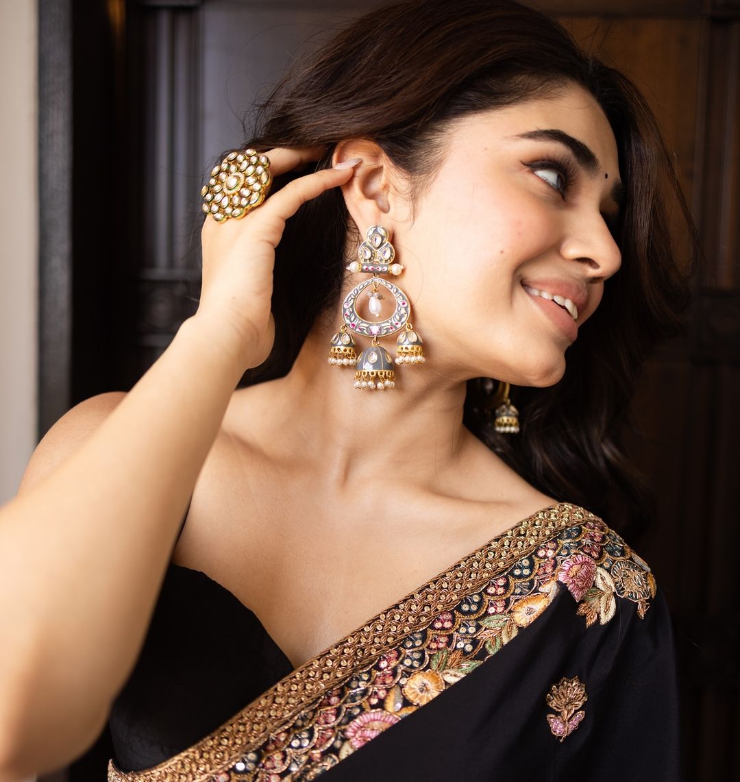 Krithi Shetty looks graceful in a black saree with intricate gold embroidery.