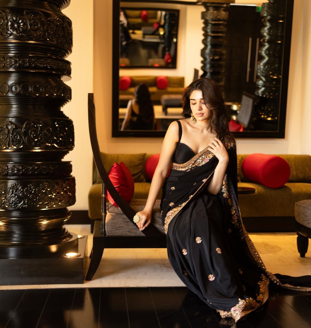 Krithi Shetty looks graceful in a black saree with intricate gold embroidery.