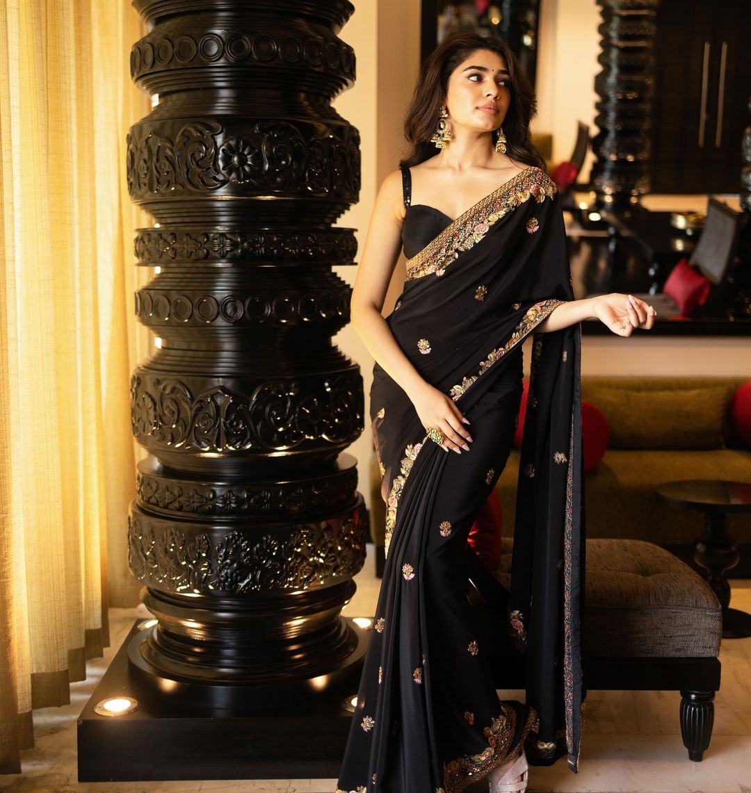 Krithi Shetty looks graceful in a black saree with intricate gold embroidery.