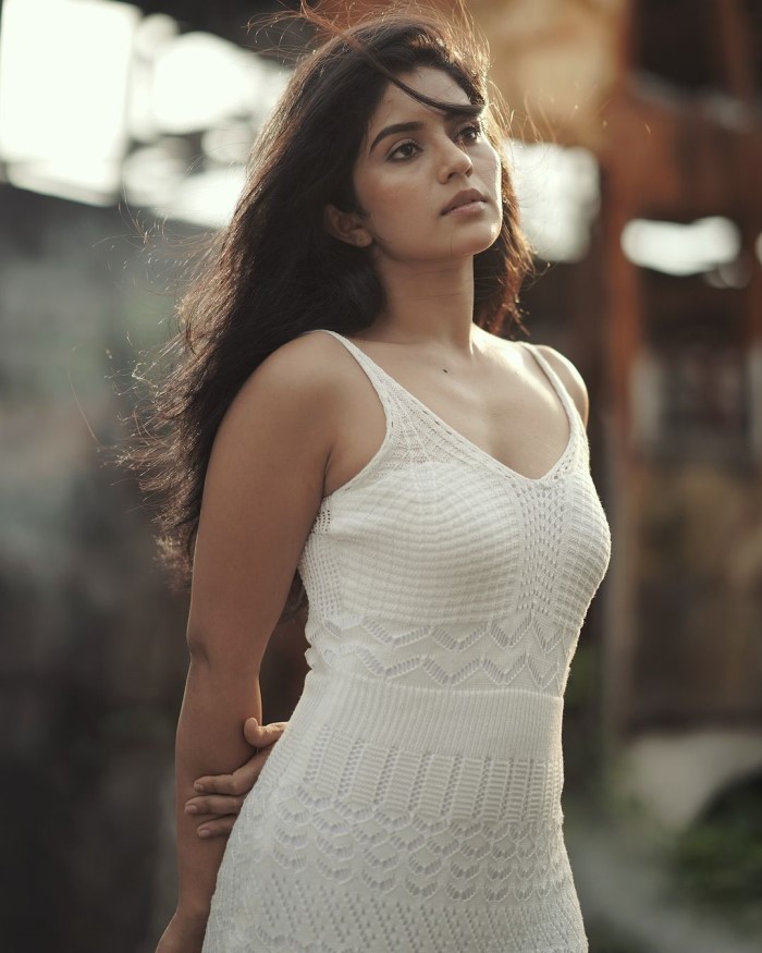 Megha Shetty is wearing a white dress, a classic choice that offers a serene and elegant look, perfect for a natural, outdoorsy photoshoot.