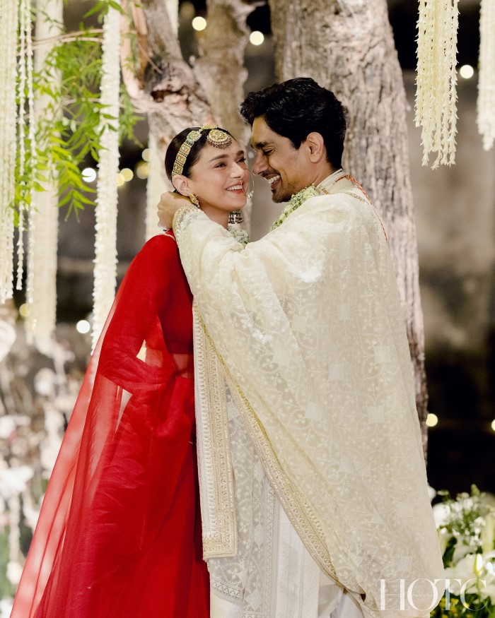 Aditi Rao Hydari stunned in a red bridal lehenga adorned with intricate kundan jewelry, while Siddharth complemented her in a beige sherwani with a pearl maharaja necklace. Their traditional attire, designed by Sabyasachi, added to the regal elegance of their wedding.