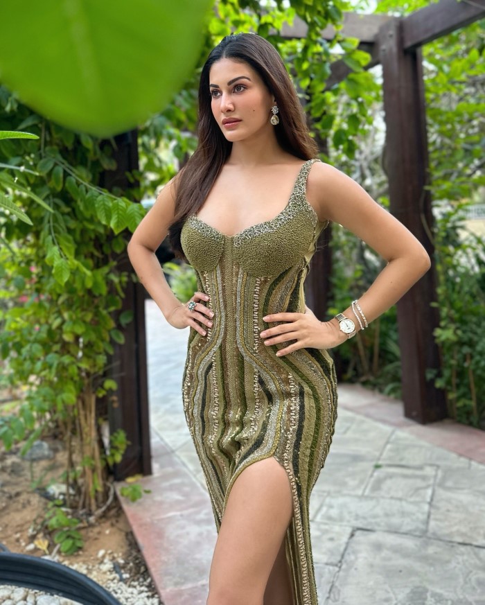 She completes the look with silver high-heeled sandals that complement the dress's elegant design, adding a chic finishing touch.