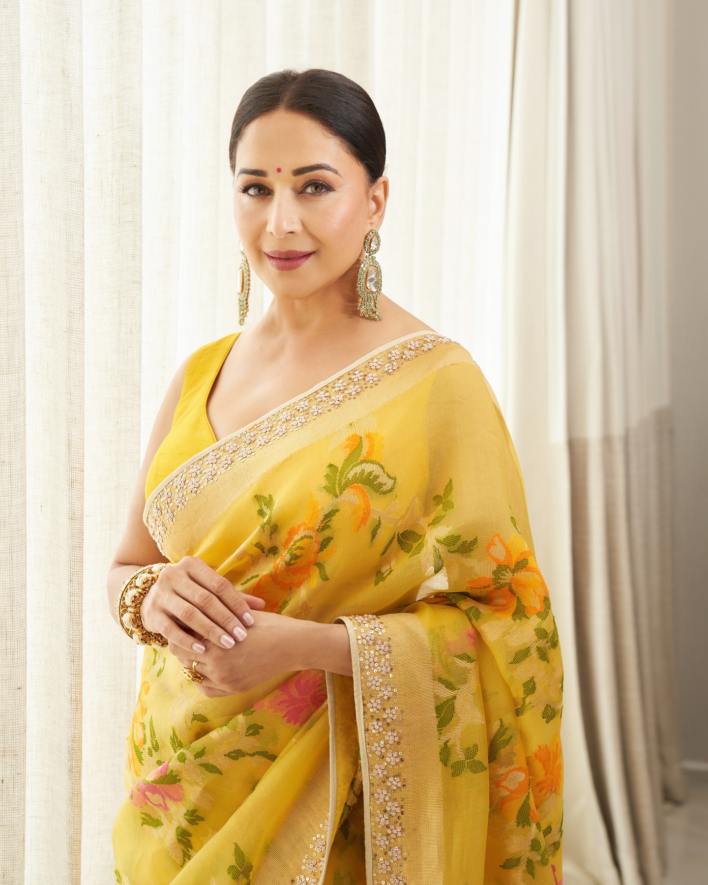 Madhuri Dixit looked breathtakingly elegant in a vibrant yellow saree adorned with delicate floral prints