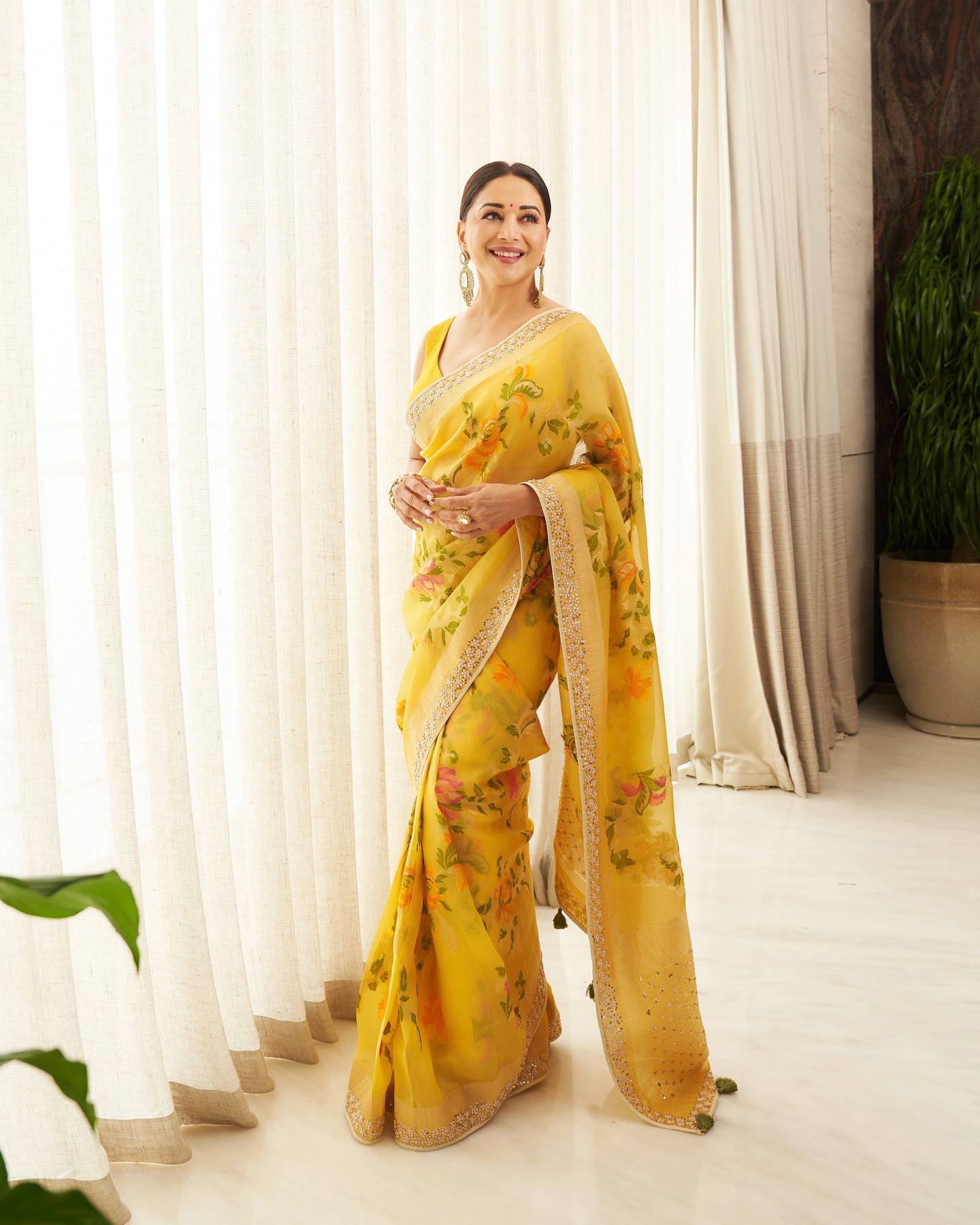 Madhuri Dixit looked breathtakingly elegant in a vibrant yellow saree adorned with delicate floral prints