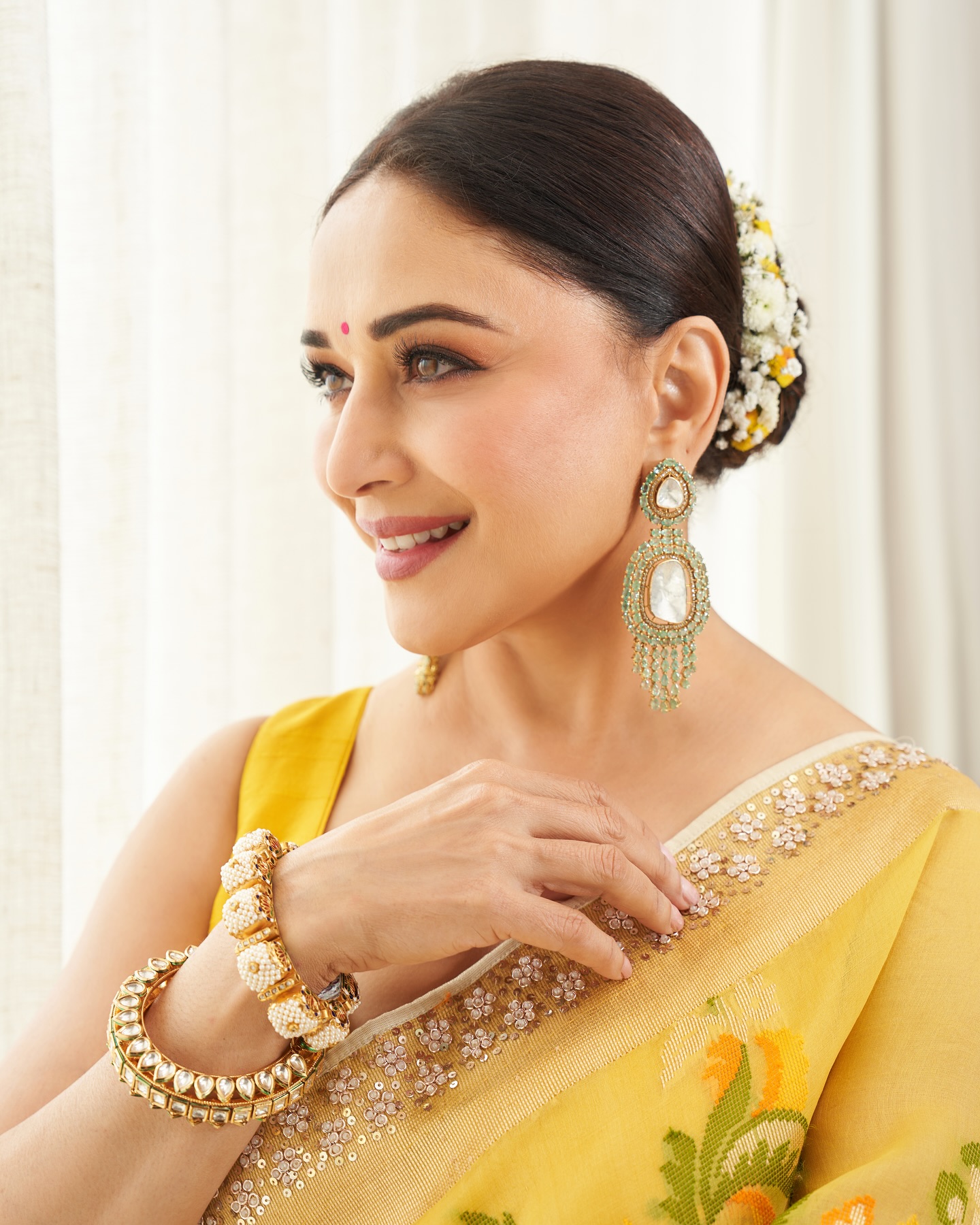 Madhuri Dixit looked breathtakingly elegant in a vibrant yellow saree adorned with delicate floral prints