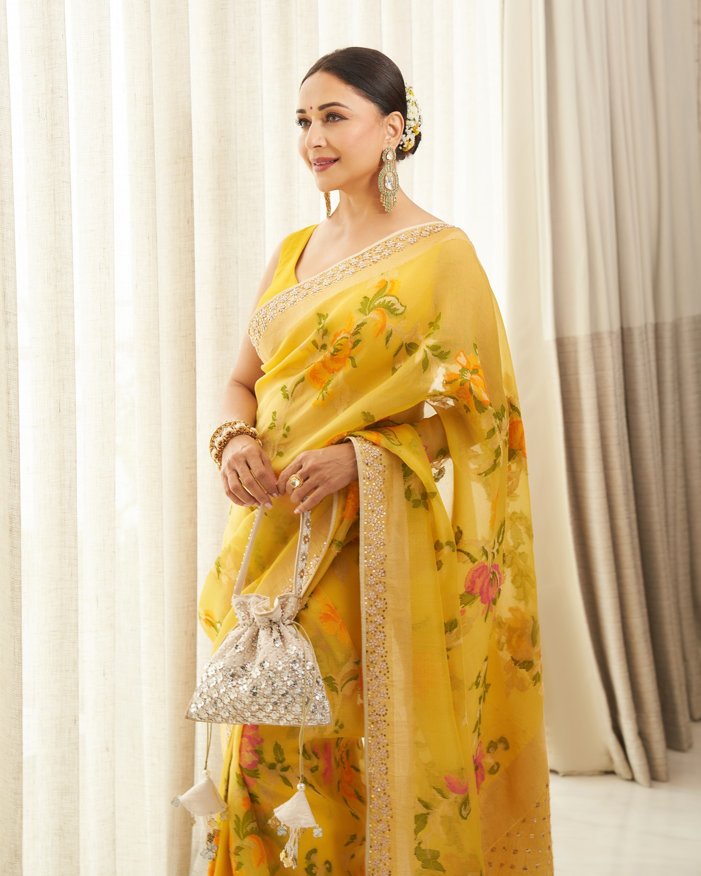 Madhuri Dixit looked breathtakingly elegant in a vibrant yellow saree adorned with delicate floral prints