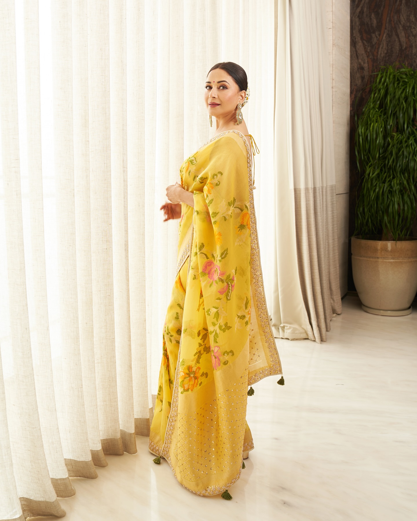 Madhuri Dixit looked breathtakingly elegant in a vibrant yellow saree adorned with delicate floral prints