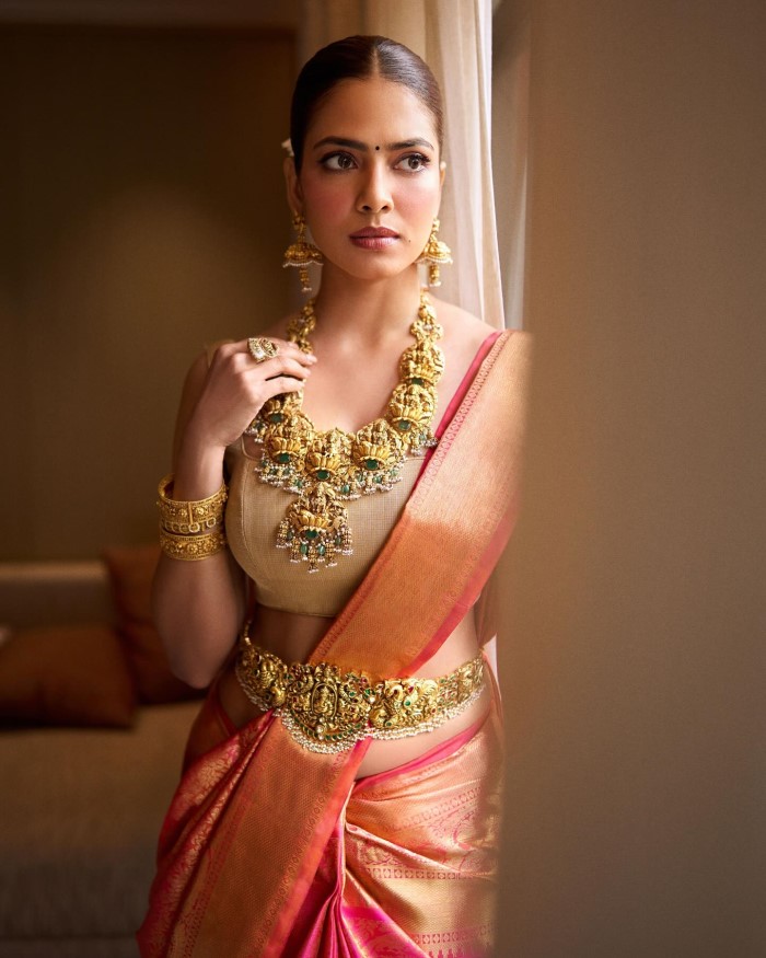 She complements her saree with traditional South Indian temple jewelry, including a statement necklace, earrings, and bangles, adding a touch of regal grandeur to her ensemble.