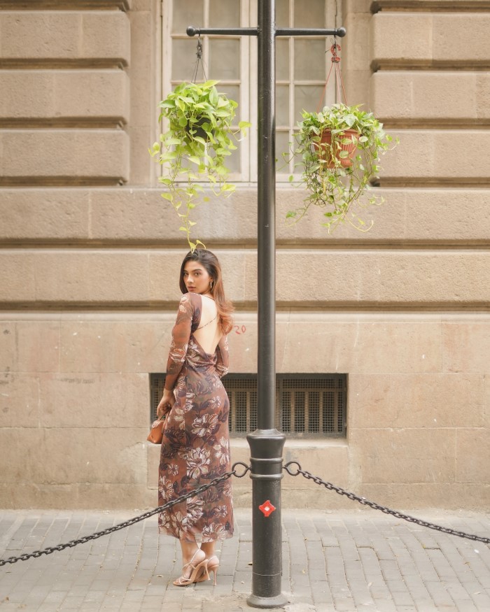 Natasha Bharadwaj shines in a long floral dress featuring shades of brown, maroon, and white, perfect for making a bold fashion statement.