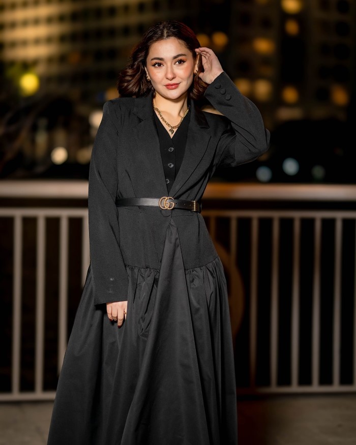 The dress features a slightly gathered or pleated skirt, which adds a touch of sophistication to the overall look.