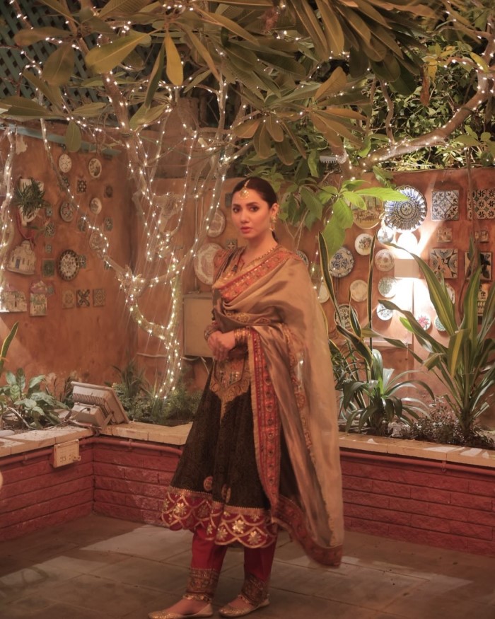 Mahira accessorizes her outfit with elegant gold jewelry, including earrings and bangles, which perfectly complement her traditional attire.
