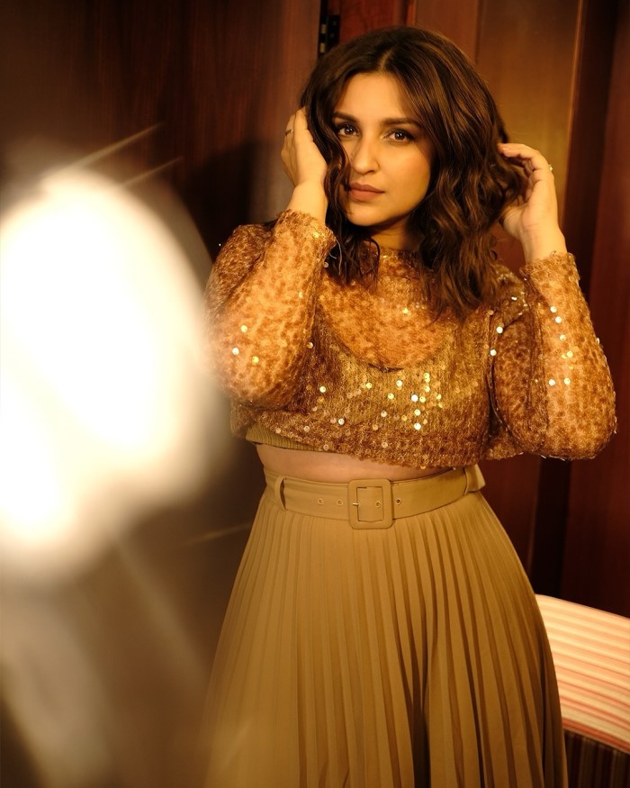 She paired the crop top with a high-waisted, pleated skirt that matched the top in color, creating a cohesive and elegant ensemble.