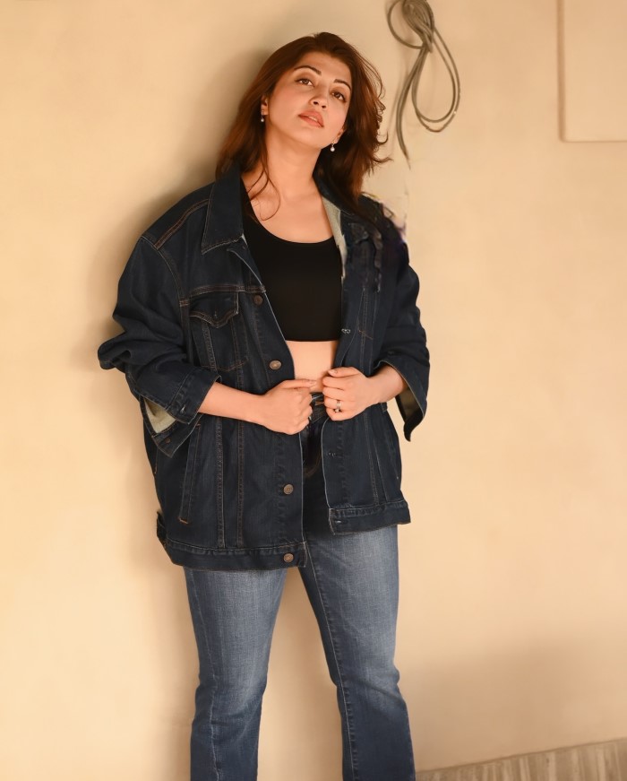 Her voluminous, wavy hair complements the casual yet polished look, adding a touch of glamor.