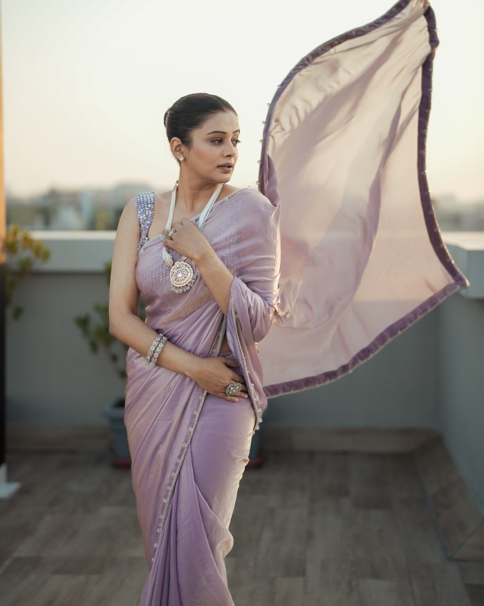 The saree features intricate embroidery and embellishments, adding a touch of glamour and intricacy to her look. The detailed work enhances the overall elegance.