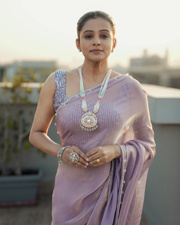 Priyamani pairs her saree with complementary accessories, including statement earrings and a delicate necklace, adding a refined touch to her ensemble.