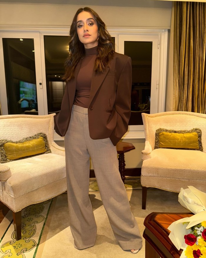 The well-furnished room with armchairs and a bouquet of flowers adds to the elegant and sophisticated ambiance of the look.