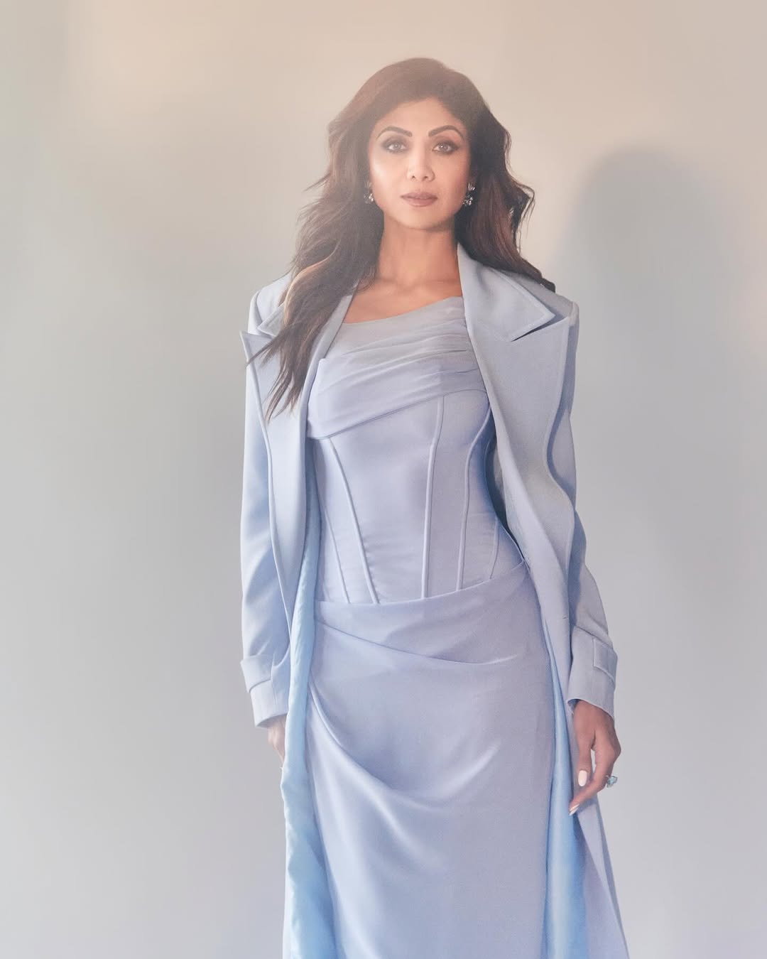 Shilpa stuns in a pastel-colored, well-fitted gown, completed with a chic overcoat.