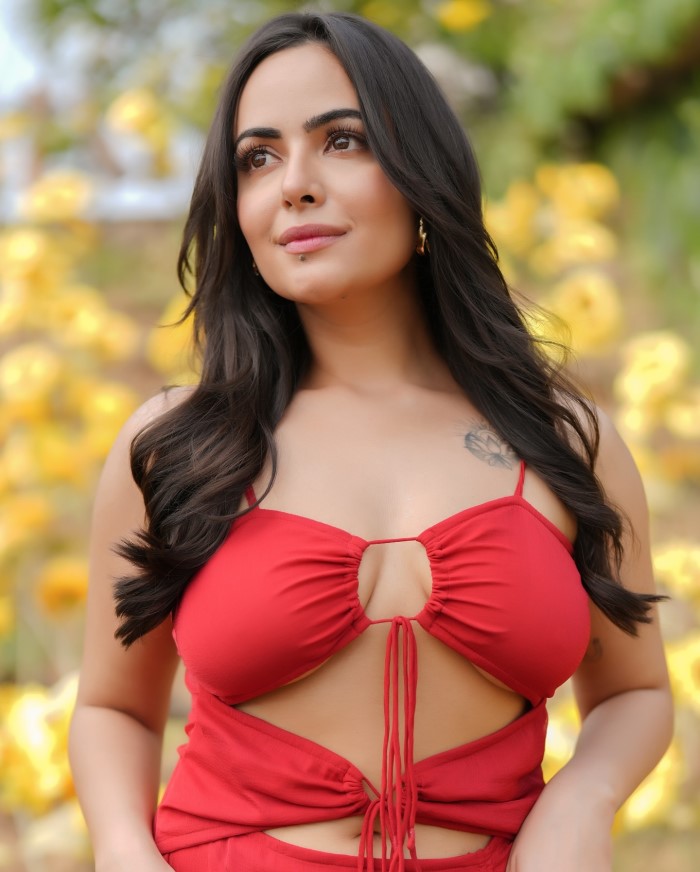 The outfit features a bold red color with stylish cut-out details and tie-up elements, adding a touch of elegance and modernity.