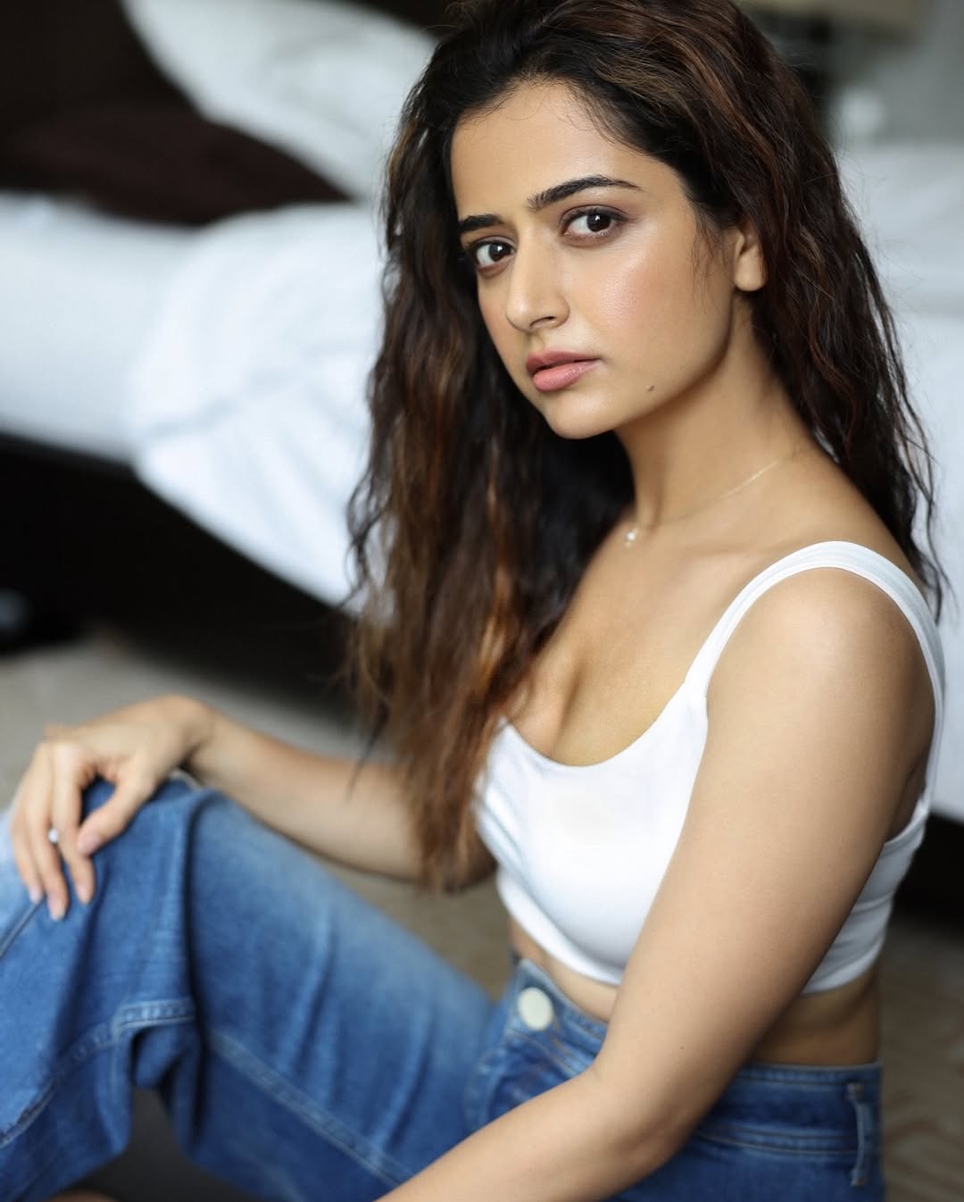 Ashika Ranganath's Stunning Photoshoot In White Crop Top And Blue Denim Jeans