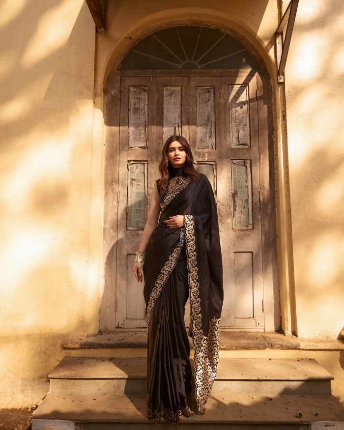 Diana Penty exudes timeless elegance in a black saree adorned with intricate gold embroidery along the border, showcasing a perfect blend of traditional and modern fashion elements.