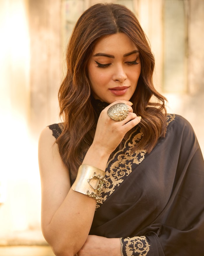 Complementing her outfit, Diana wears a large statement ring and a wide metallic bracelet, adding a touch of glamour and sophistication to her overall look.