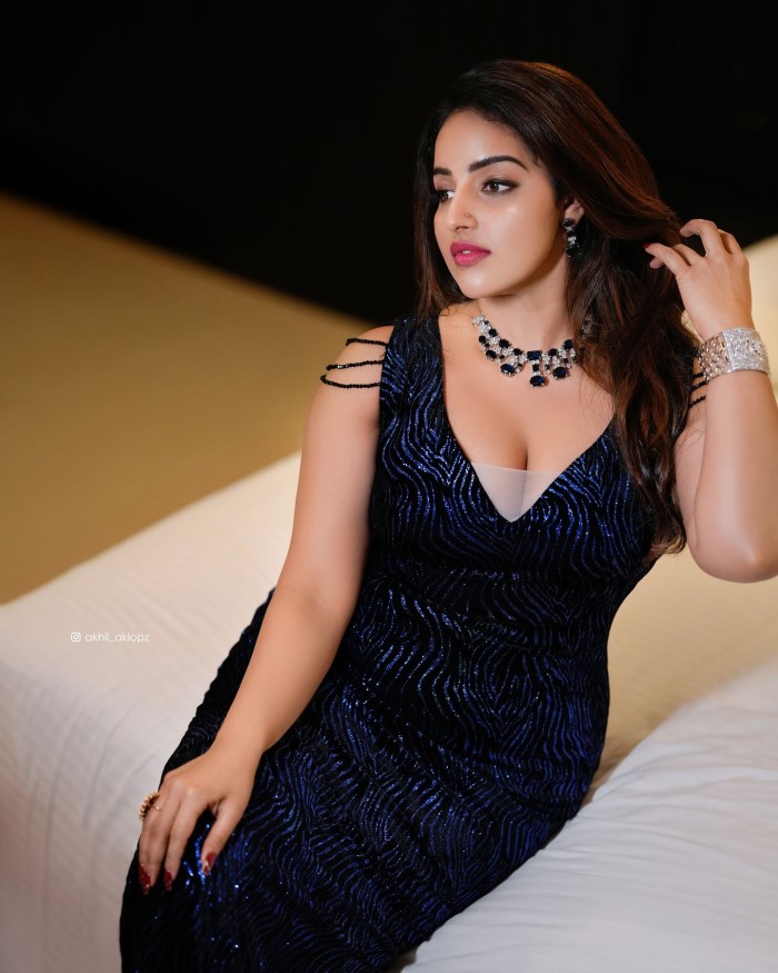 Malavika stuns in a shimmering navy-blue gown with intricate patterns, perfect for formal events or red-carpet occasions. The thigh-high slit adds a touch of allure and elegance.