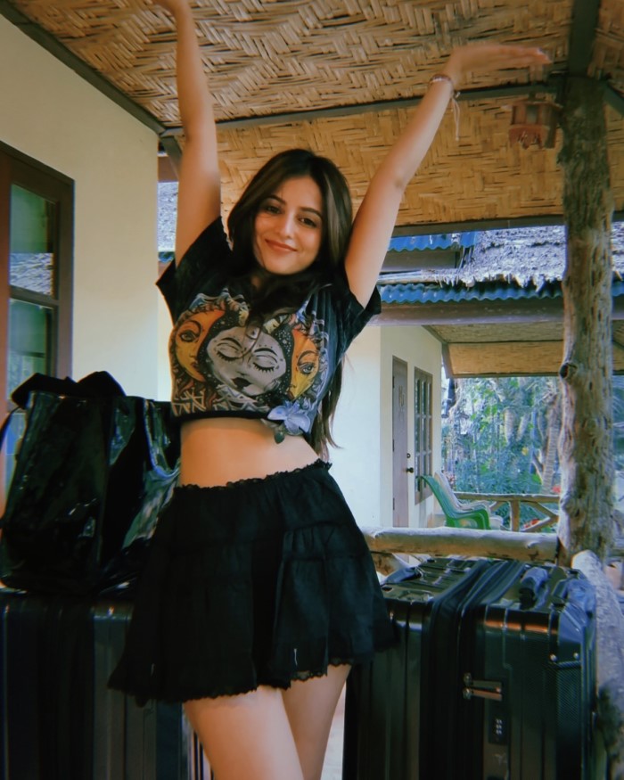 Her relaxed and confident pose complements the attire, elevating the outfit's appeal further.