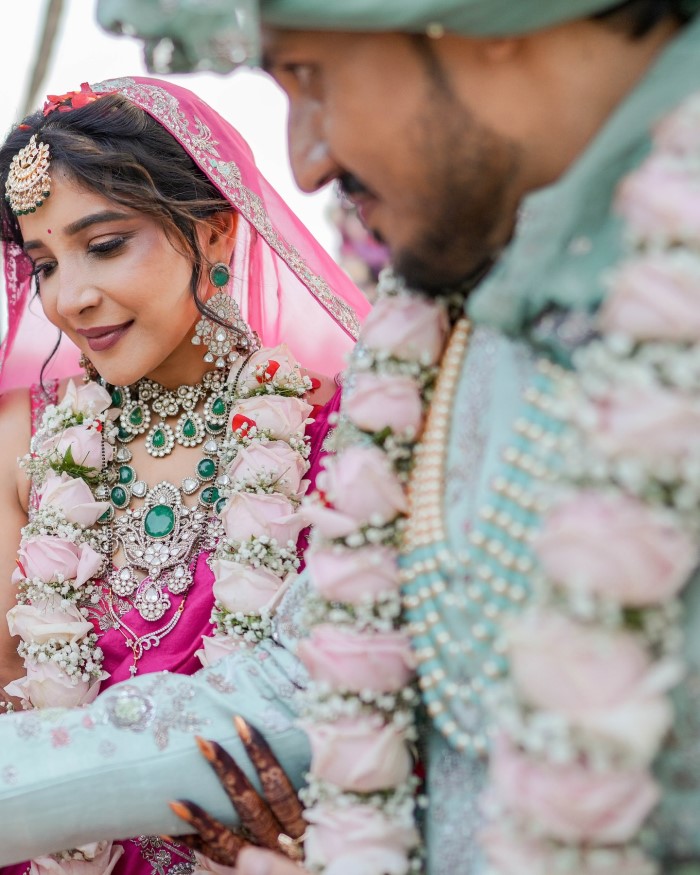 Sakshi dazzled in a pink lehenga adorned with exquisite green Kundan jewelry, while Navneet complemented her in a mint green sherwani, creating a stunning visual.