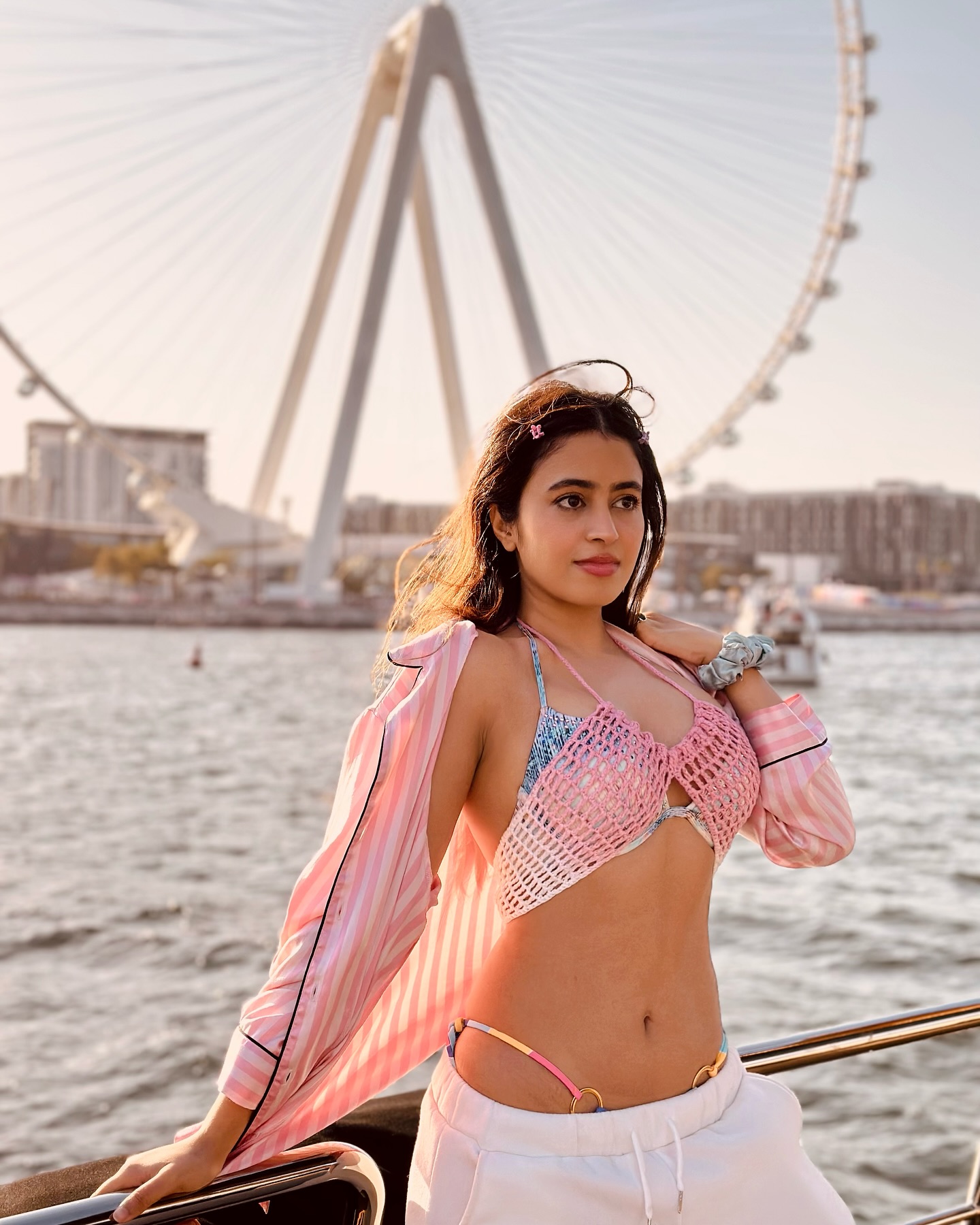Shobhita Rana stuns in a chic pink and white crochet bikini top, paired with trendy white joggers, perfect for a breezy yacht day in Dubai.