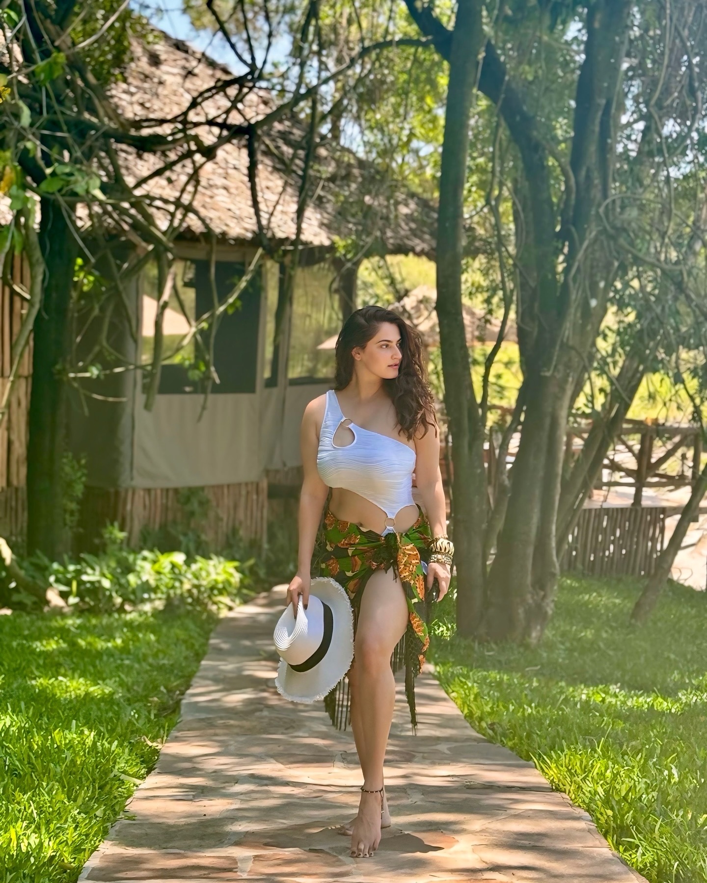 Shivaleeka Oberoi wears a stylish white cut-out bodysuit paired with a vibrant floral sarong, making for a perfect tropical getaway look.