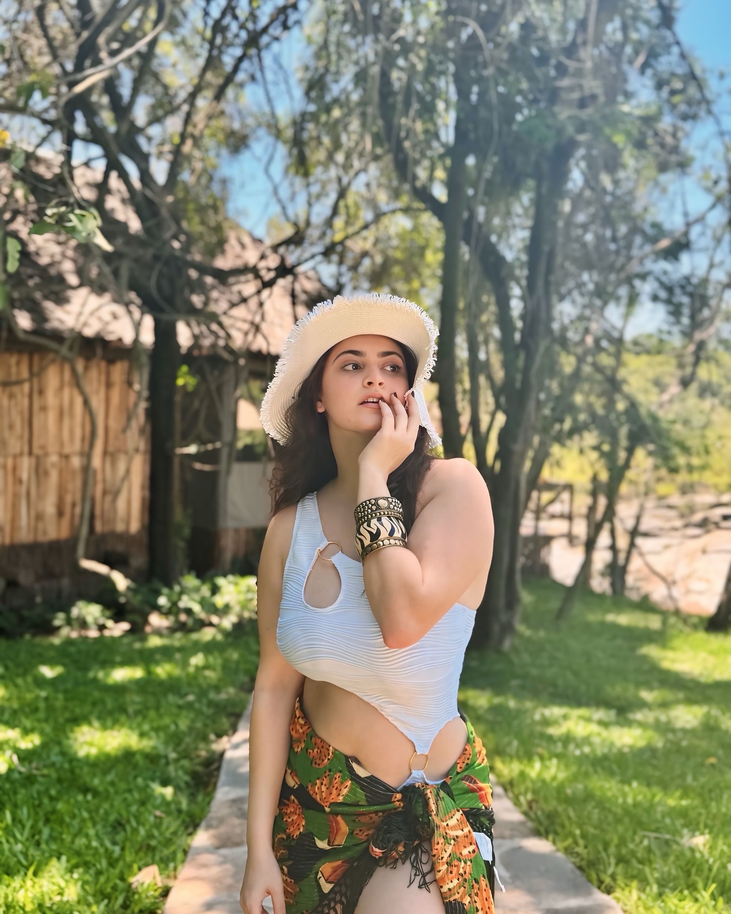 Shivaleeka Oberoi wears a stylish white cut-out bodysuit paired with a vibrant floral sarong, making for a perfect tropical getaway look.