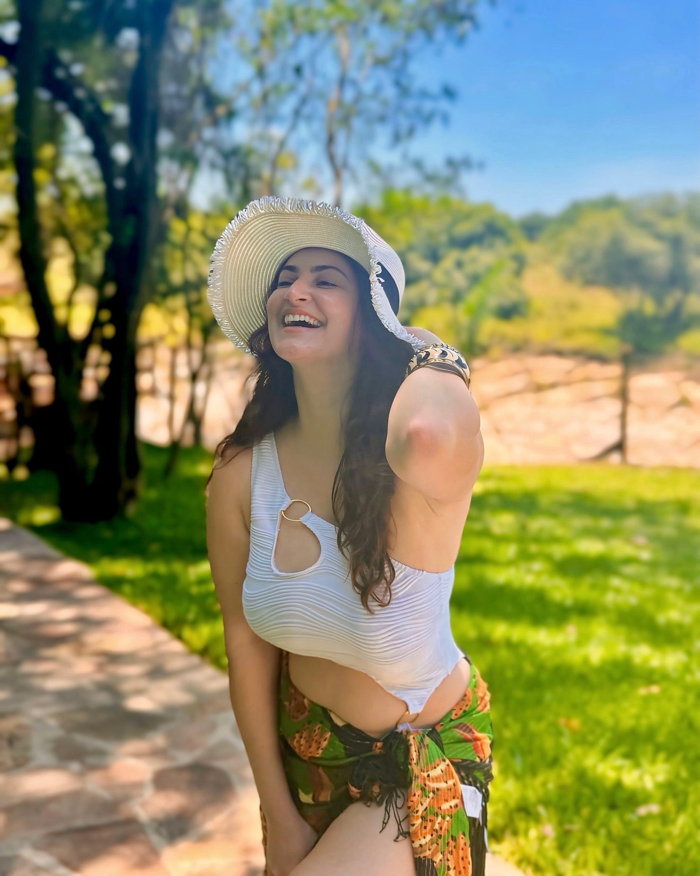 Shivaleeka Oberoi wears a stylish white cut-out bodysuit paired with a vibrant floral sarong, making for a perfect tropical getaway look.